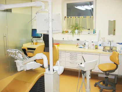 Behandlungszimmer mit gelbem Behandlungsstuhl