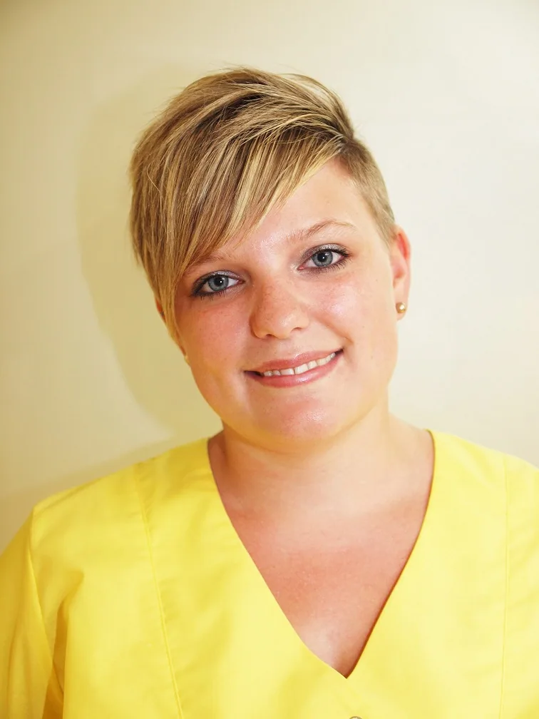 Assistentin Karin in gelber Praxiskleidung